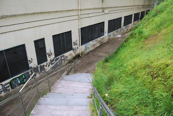 Azitain Eibar: acceso a través de tramo de escaleras no acondicionado. El recorrido hacia las escaleras está en pendiente, con baja iluminación y pavimento en mal estado. Inseguridad